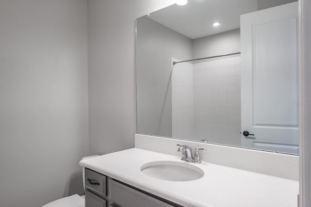 bathroom with walk in shower, vanity, and toilet