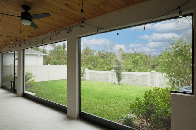 unfurnished sunroom with wooden ceiling and ceiling fan