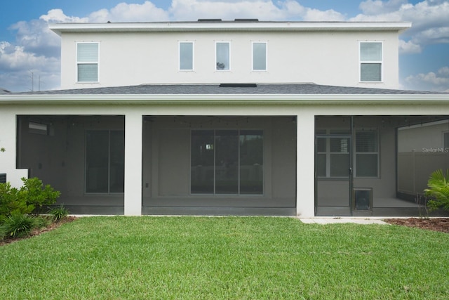 back of property with a sunroom and a yard