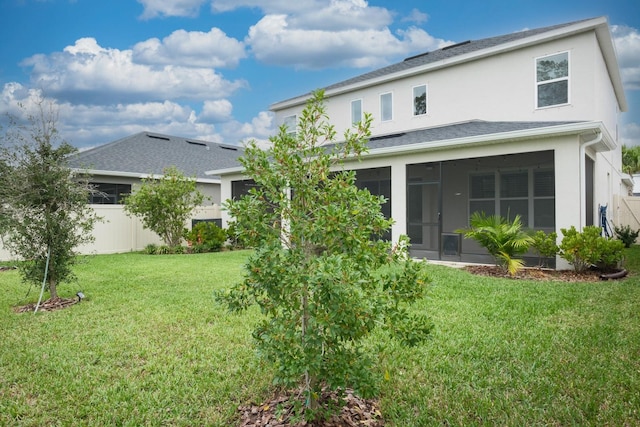 back of house featuring a lawn and a sunroom