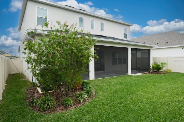 back of house with a sunroom and a yard