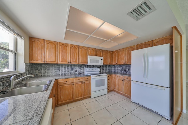 kitchen featuring decorative backsplash, sink, light tile patterned floors, and white appliances