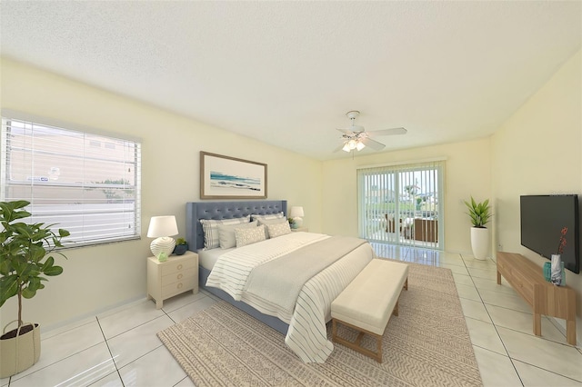 bedroom with ceiling fan, light tile patterned flooring, and a textured ceiling