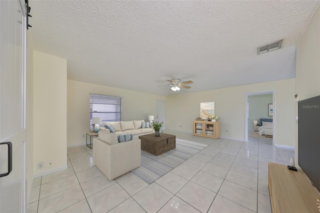 tiled living room featuring ceiling fan and a textured ceiling