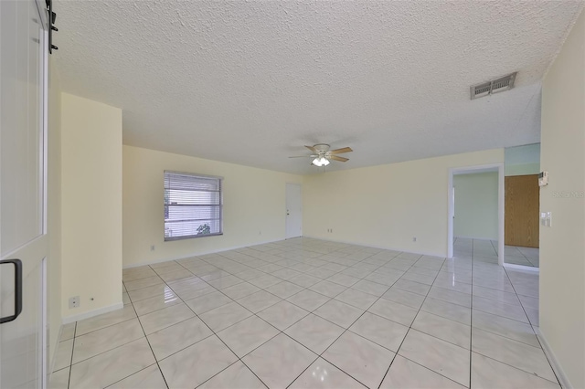 tiled spare room with ceiling fan and a textured ceiling