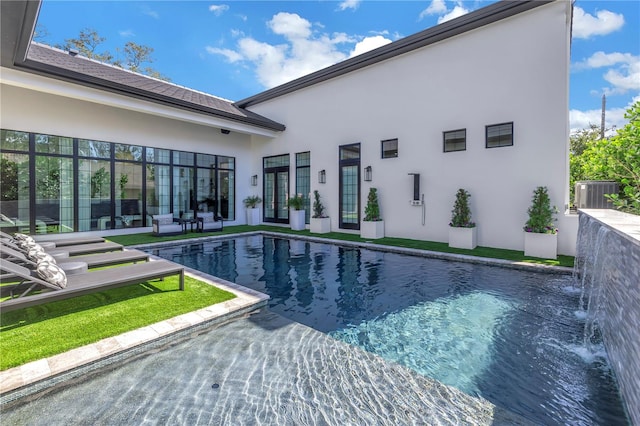 view of swimming pool with pool water feature, cooling unit, and a patio