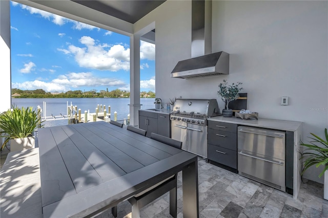 view of patio / terrace with area for grilling, a water view, exterior kitchen, and sink