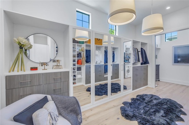 bathroom with washer / clothes dryer, hardwood / wood-style floors, vanity, and a high ceiling