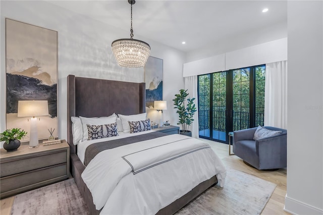 bedroom with access to exterior, french doors, light wood-type flooring, and an inviting chandelier