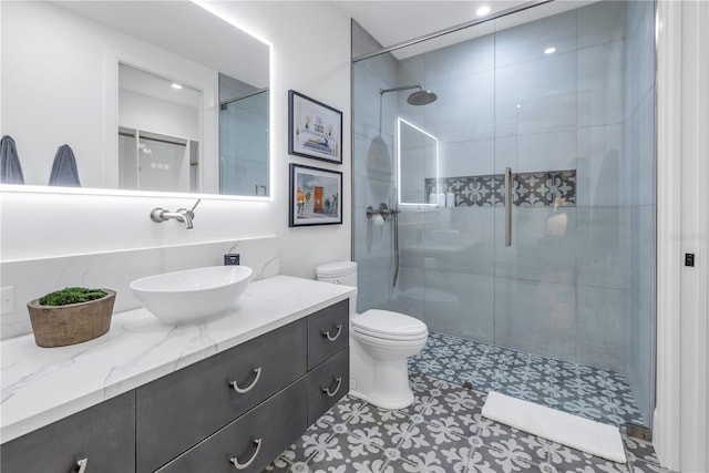 bathroom featuring vanity, toilet, and a shower with shower door