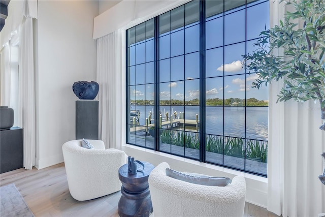 sitting room featuring plenty of natural light, a water view, and hardwood / wood-style flooring