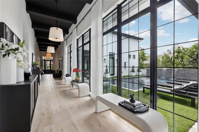 interior space with light wood finished floors and a high ceiling