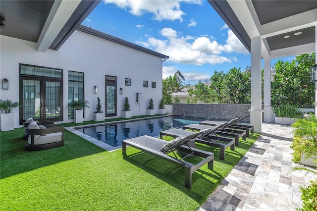 outdoor pool featuring a yard, french doors, and a patio