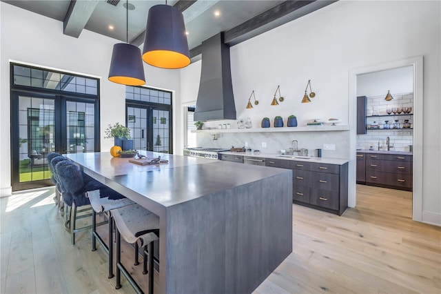 kitchen with french doors, open shelves, hanging light fixtures, dark brown cabinetry, and beamed ceiling