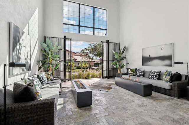 living area featuring stone finish floor and a towering ceiling