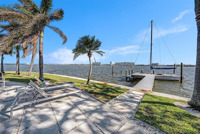 view of dock featuring a lawn and a water view