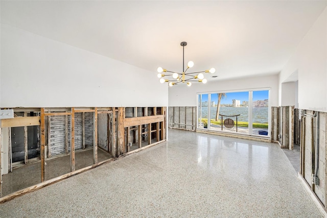 empty room featuring a water view and a chandelier