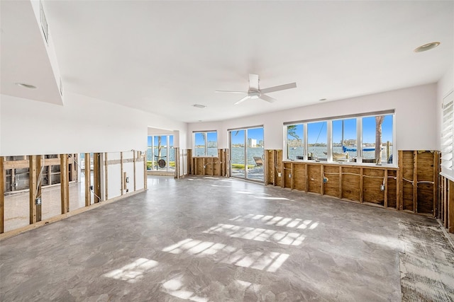 interior space with ceiling fan and concrete flooring