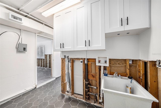 laundry area with cabinets, dark tile patterned floors, and hookup for a washing machine