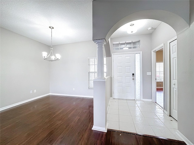 entryway with a wealth of natural light, a textured ceiling, and light hardwood / wood-style flooring