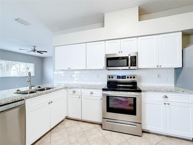 kitchen featuring white cabinets, decorative backsplash, stainless steel appliances, and sink