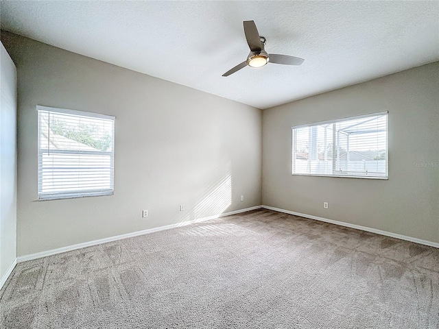 spare room featuring a textured ceiling, carpet flooring, and ceiling fan