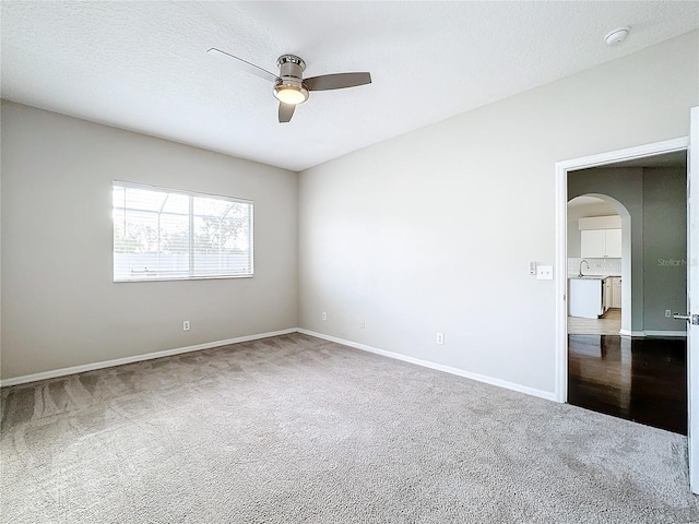 empty room with ceiling fan, a textured ceiling, and carpet floors