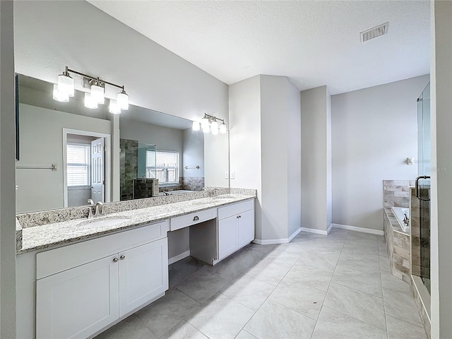 bathroom featuring shower with separate bathtub, vanity, and a textured ceiling