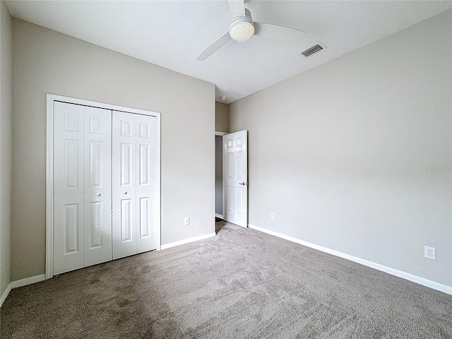 unfurnished bedroom with ceiling fan, a closet, and carpet floors