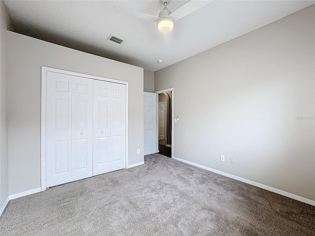 unfurnished bedroom featuring ceiling fan, a closet, and carpet