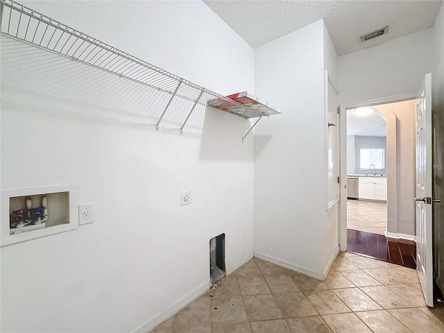 laundry area featuring hookup for an electric dryer, light hardwood / wood-style flooring, washer hookup, and sink