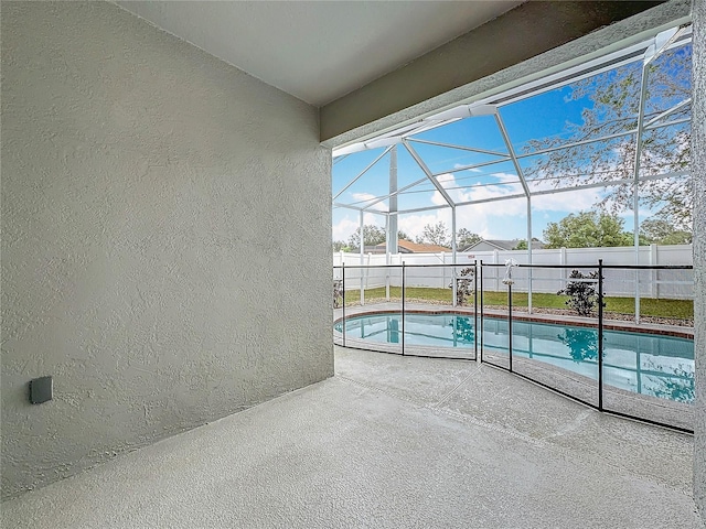 view of pool featuring glass enclosure and a patio area