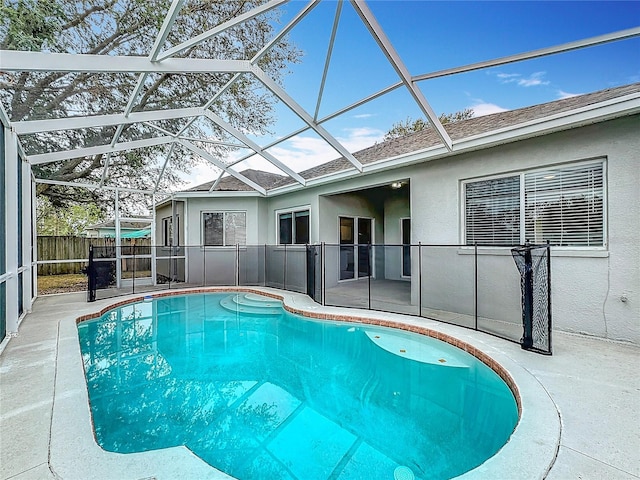 view of swimming pool featuring glass enclosure and a patio area