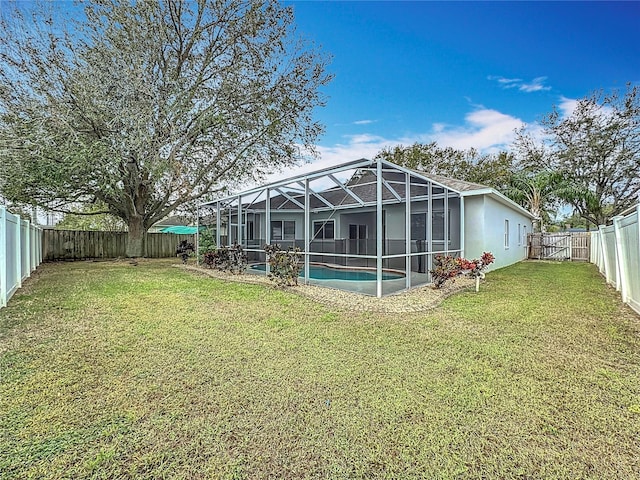 back of property featuring a lanai, a yard, and a fenced in pool