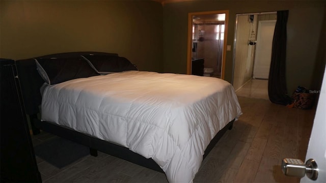 bedroom with ensuite bathroom, wood-type flooring, and a closet