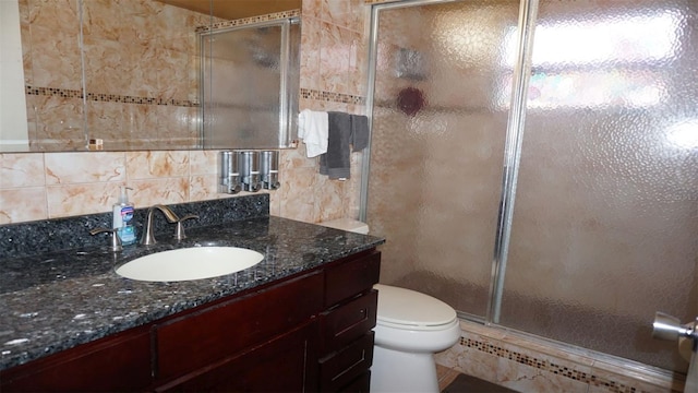 bathroom featuring an enclosed shower, vanity, and toilet