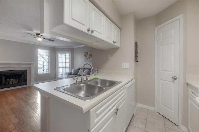 kitchen featuring kitchen peninsula, light wood-type flooring, a textured ceiling, sink, and white cabinets