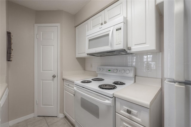 kitchen featuring white appliances, a textured ceiling, tasteful backsplash, light tile patterned flooring, and white cabinetry