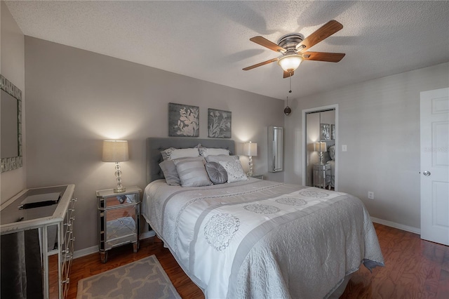 bedroom featuring a textured ceiling, ceiling fan, and dark wood-type flooring