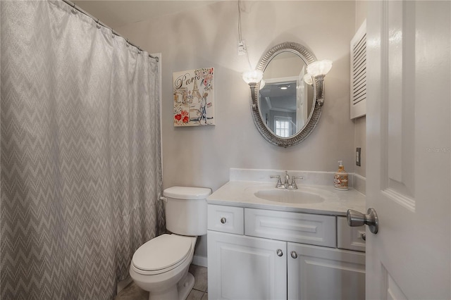 bathroom with tile patterned flooring, vanity, and toilet