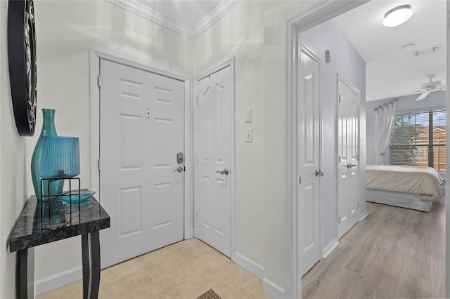 foyer entrance featuring ornamental molding, light hardwood / wood-style floors, and ceiling fan