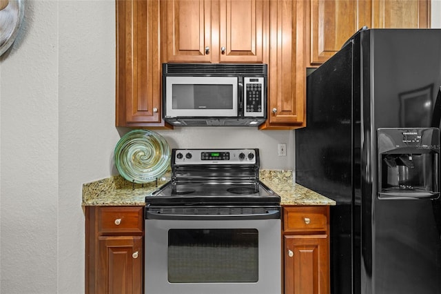 5000 Culbreath Key Way Unit 4-206, Tampa, FL 33611 - kitchen featuring black fridge with ice dispenser, electric range, a textured wall, light stone counters, and brown cabinets