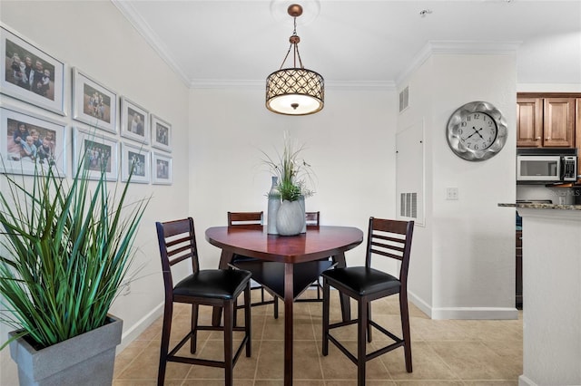 dining room with light tile patterned floors and ornamental molding