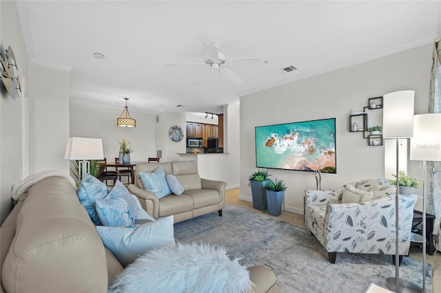 living room with ceiling fan and ornamental molding