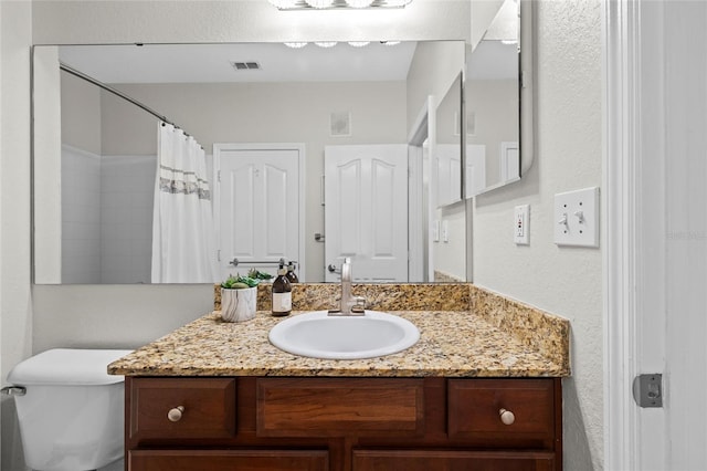 bathroom featuring vanity, toilet, and a shower with curtain