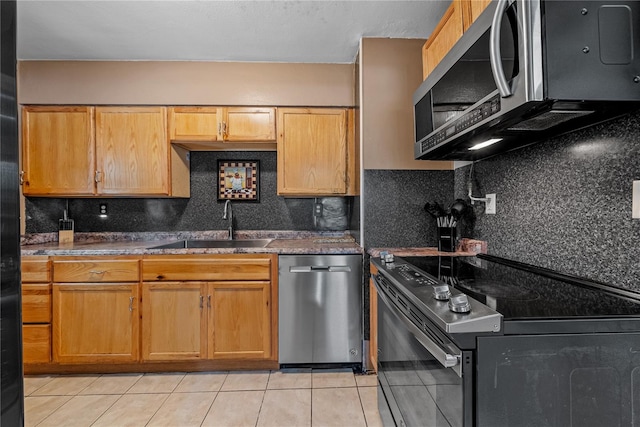 kitchen with backsplash, sink, light tile patterned floors, and stainless steel appliances