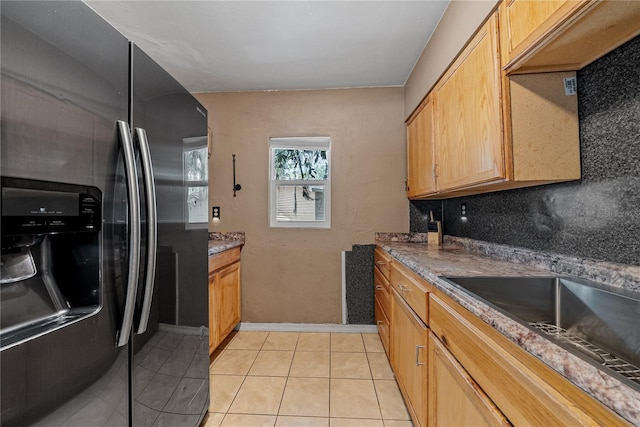 kitchen featuring decorative backsplash, light brown cabinetry, sink, fridge with ice dispenser, and light tile patterned flooring