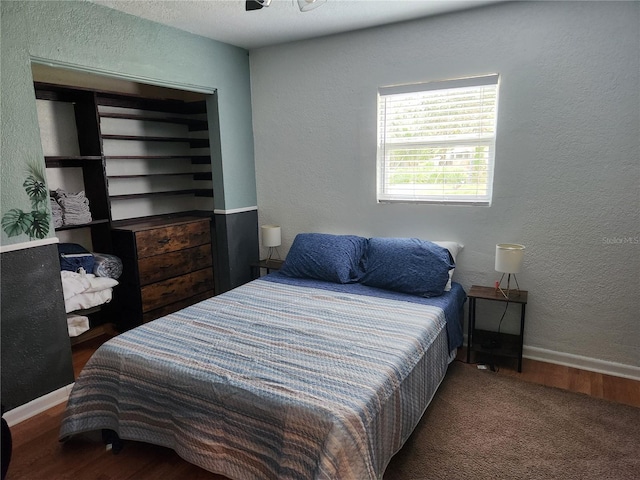 bedroom with dark hardwood / wood-style floors and ceiling fan