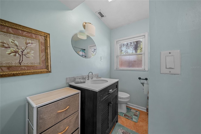 bathroom with toilet, vanity, tile patterned floors, and lofted ceiling