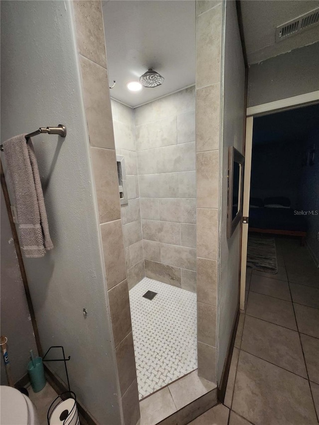 bathroom featuring tile patterned floors and tiled shower